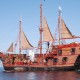 ship with sails and pirates climbing